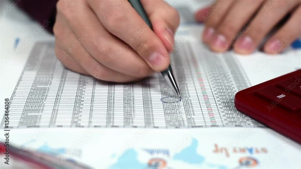 Trader Man With Pen In Hand And Analyzes Stock Exchange Statistics Trader Man With Pen In Hand And Analyzes Stock Exchange Statistics