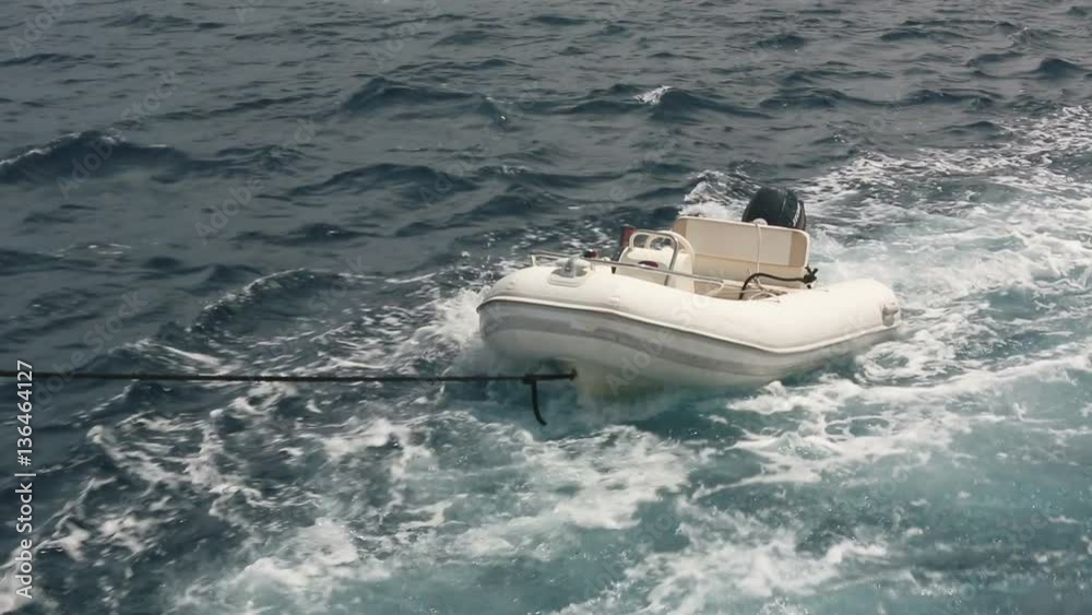 Inflatable empty boat tied to the yacht Inflatable empty boat tied to the yacht