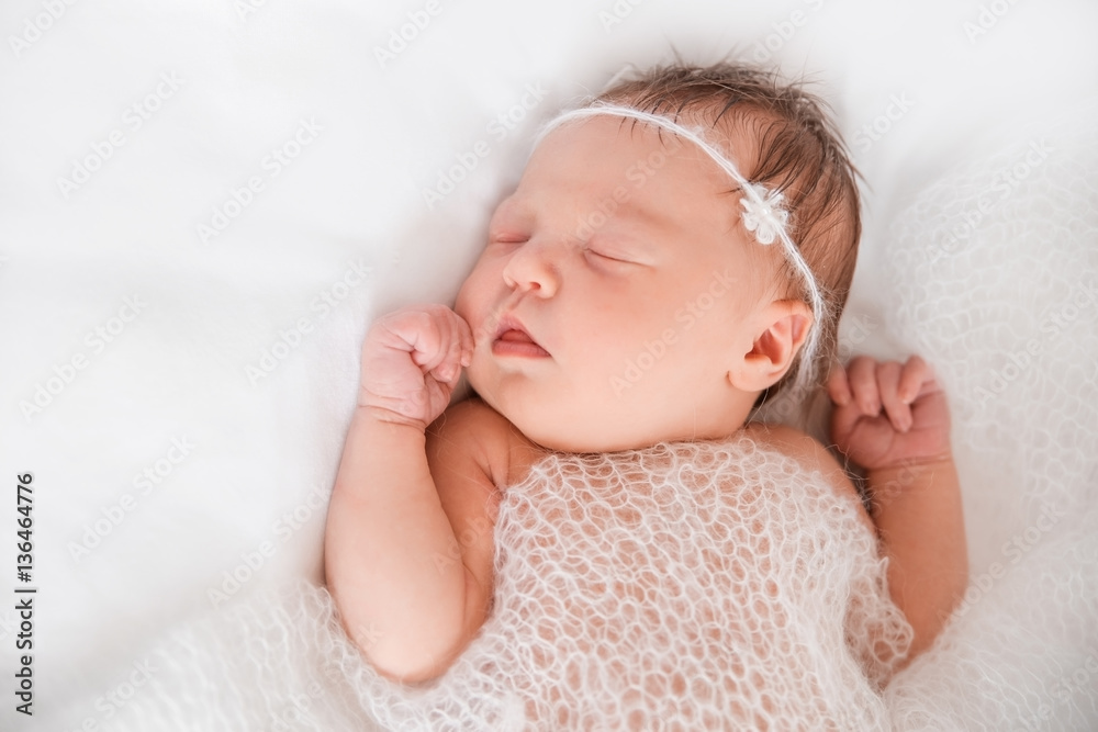 Sleeping newborn girl under a fluffy knitted blanket. Sleeping newborn girl under a fluffy knitted blanket.