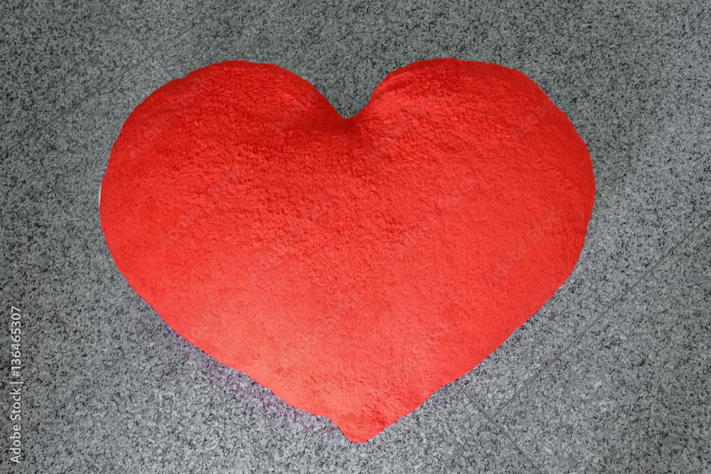Valentine red heart-shaped pillow on the marble floor Valentine red heart-shaped pillow on the marble floor