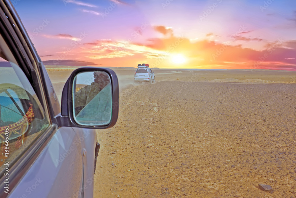 Driving through the Sahara Desert in Morocco at sunset