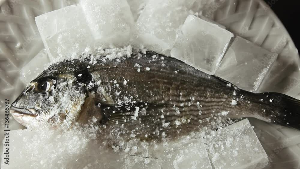 Covering a raw fish with ice.
Covering a raw fish with ice.