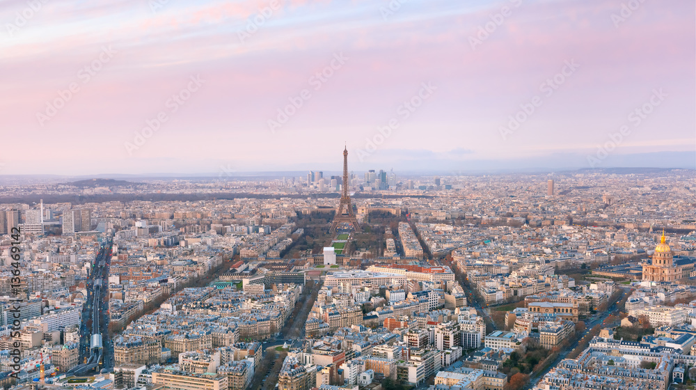 Aerial panoramic view of Paris skyline with Eiffel Tower, Les Invalides and business district of Defense at pink sunset, as seen from Montparnasse Tower, Paris, France