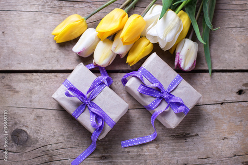 Spring tulips and wrapped boxes with presents on vintage back
