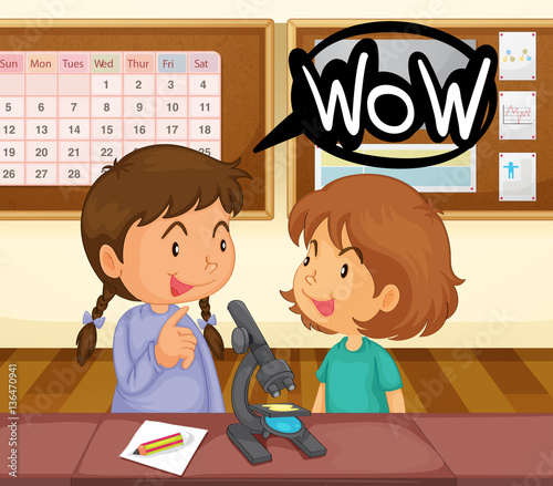 Two girls looking at microscope in classroom