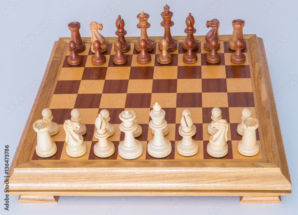 Chess pieces in starting position on a wooden Board Chess pieces in starting position on a wooden Board