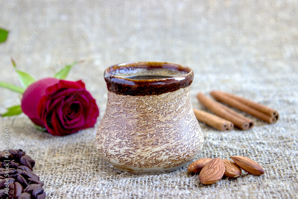 cup of black coffee with coffee beans and cinnamon, red rose cup of black coffee with coffee beans and cinnamon, red rose
