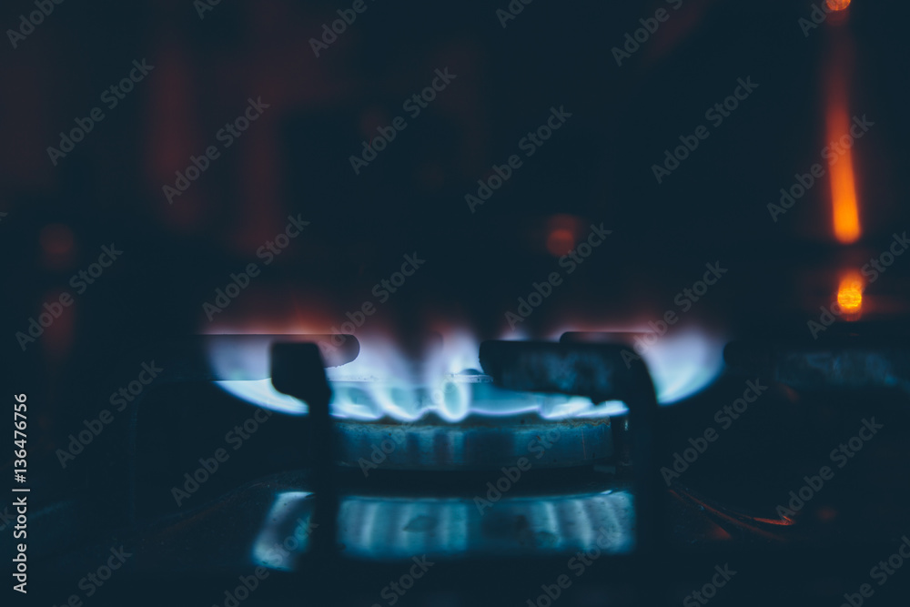 lit burner on the gas stove in the dark