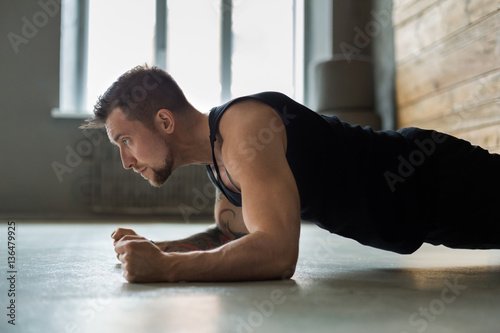 Young man fitness workout, elbow plank © Prostock-studio