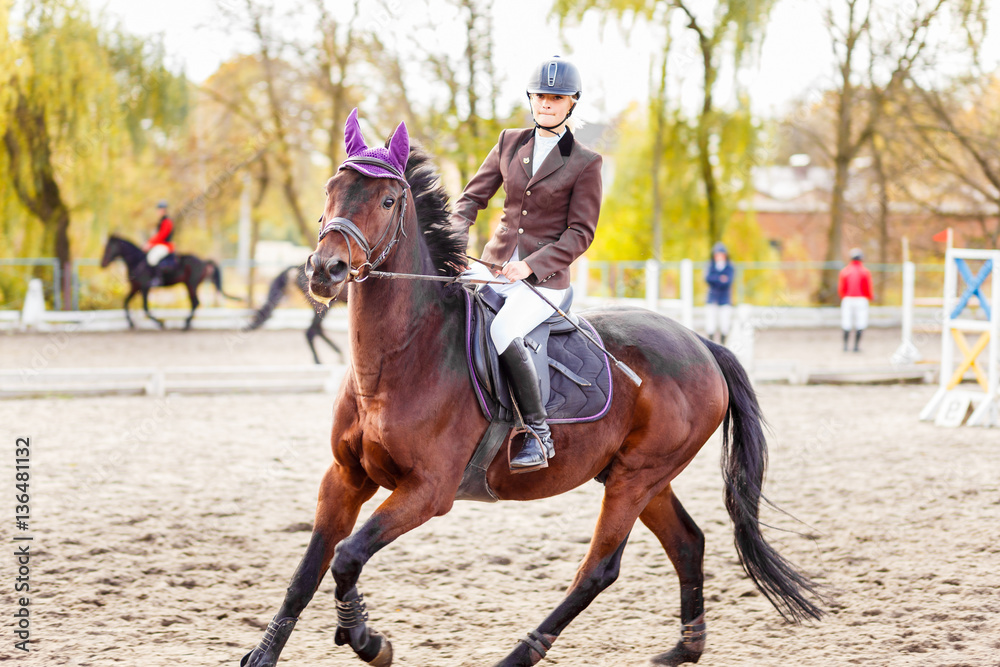 Young jockey girl riding horse on equestrian sport competition Young jockey girl riding horse on equestrian sport competition