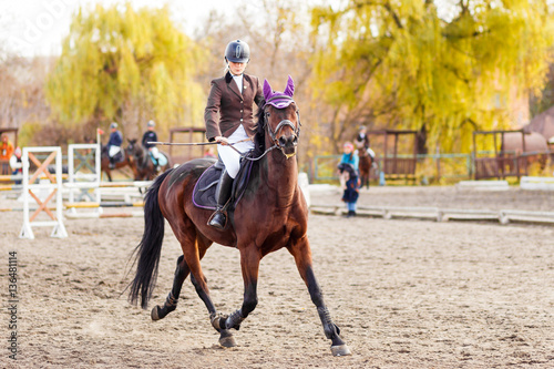 Young jockey girl riding horse on equestrian sport competition © skumer