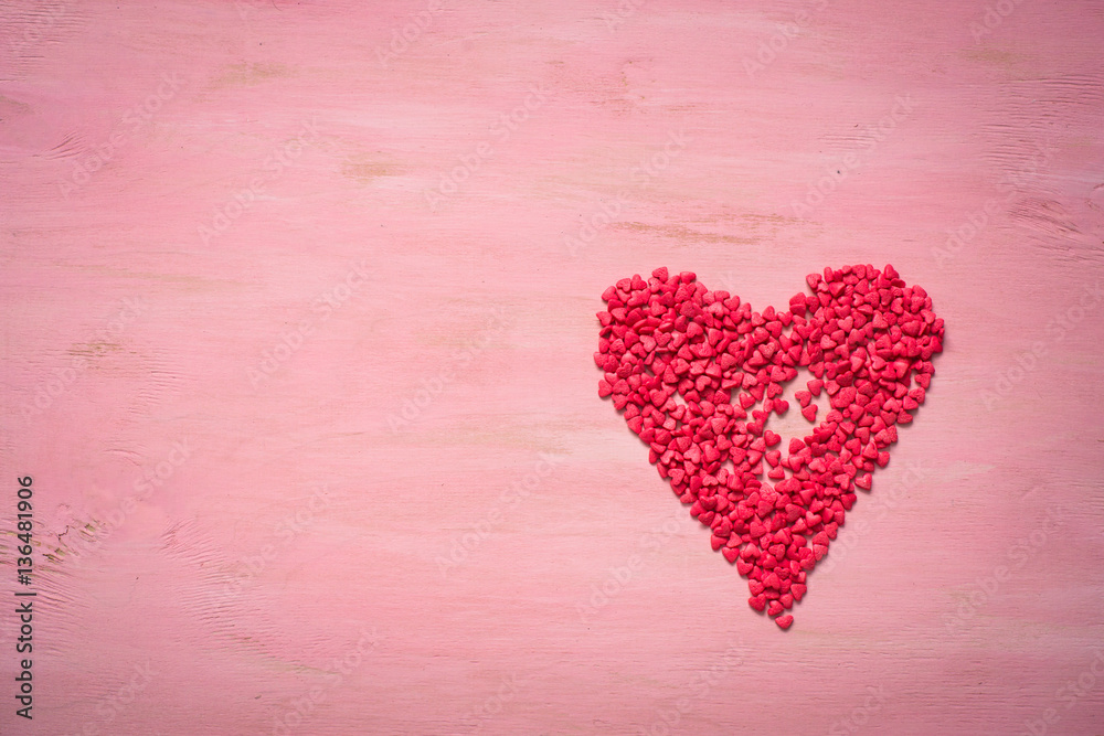 Red heart on pink wooden background. Love and Valentine day symb
