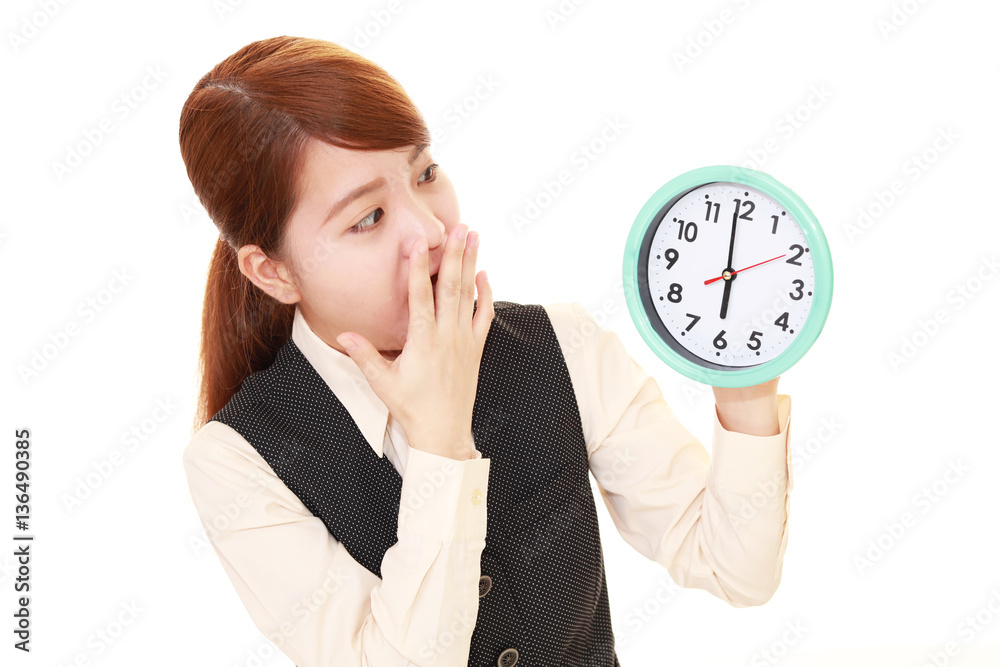 時計を持つ驚いた表情の女性
