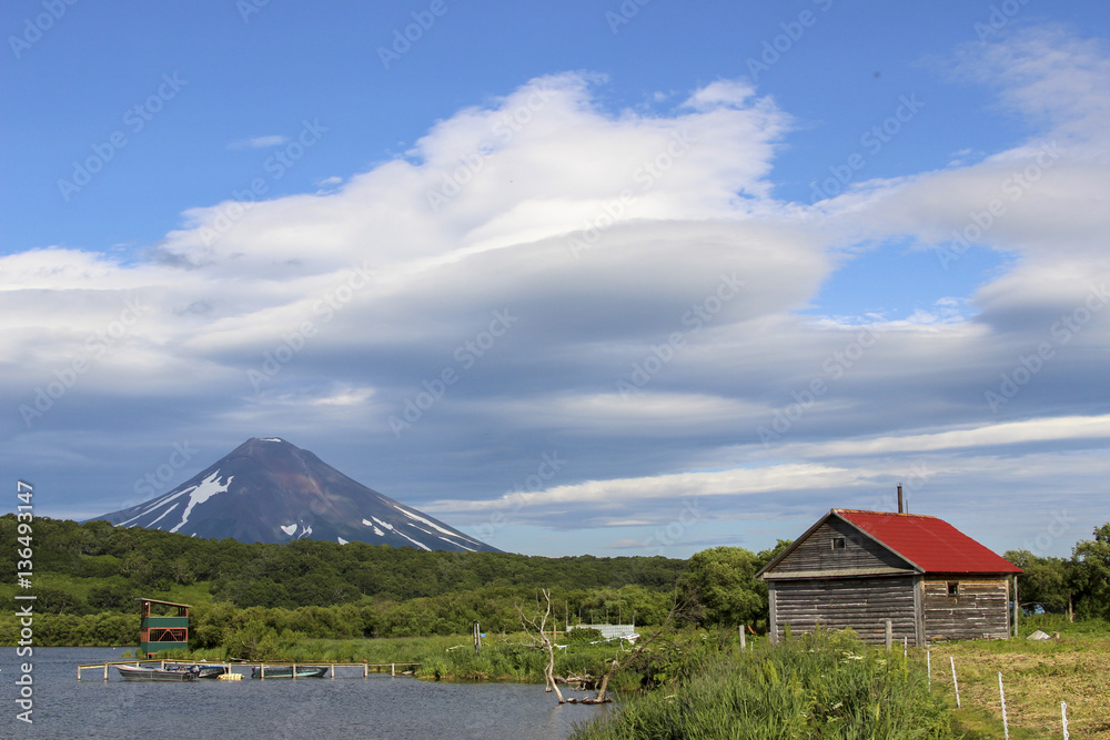 The house and volcano. A typical Russian view. Russia, Far East, Kurile lake, South Kamchatka Sanctuary