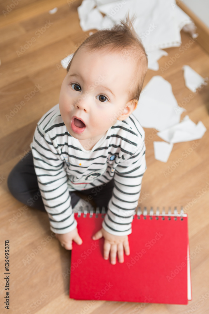 Ten months old baby girl playing with papers and paper folder on Ten months old baby girl playing with papers and paper folder on