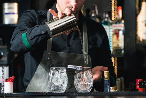 bartender making relaxing coctail on a bar background photo