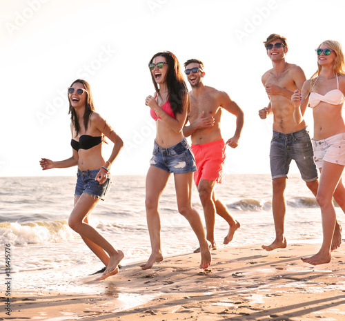 Happy friends running on beach