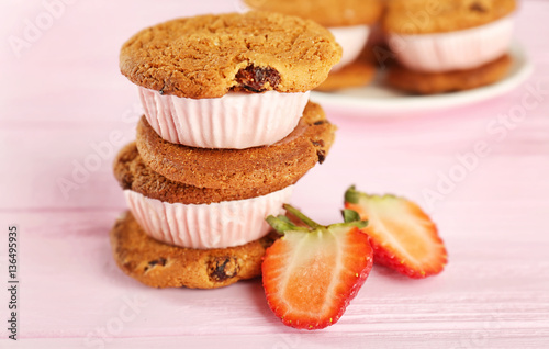 Ice cream cookie sandwiches with fresh strawberry on pink wooden background