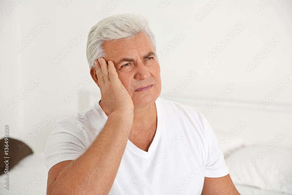 Senior gentleman suffering from pain in bedroom Senior gentleman suffering from pain in bedroom