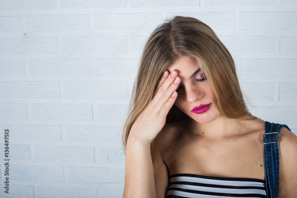portrait of beautiful female model in jeans. The sad emotions. Headache. Problems or fatigue. portrait of beautiful female model in jeans. The sad emotions. Headache. Problems or fatigue.