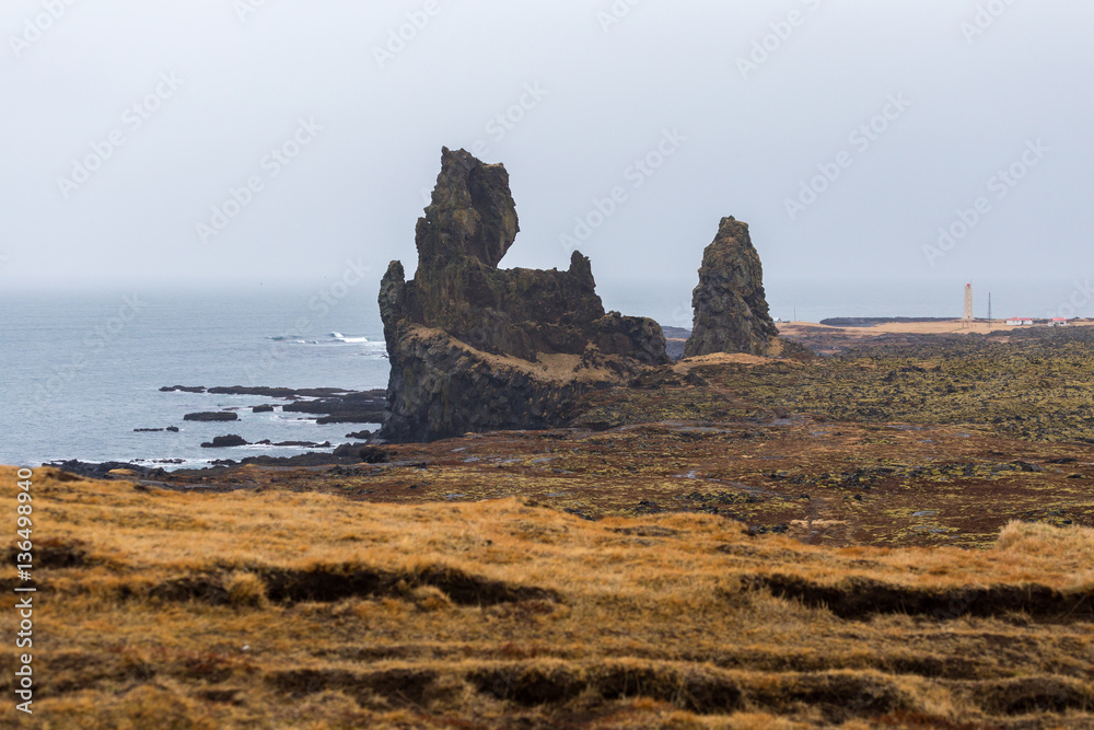 The cliffs at Londrangar, two basalt pinnacles rising from the coastline of the Snaefellsnes peninsula in Iceland. The rock formations remain from volcanic plugs after the softer outer layers eroded