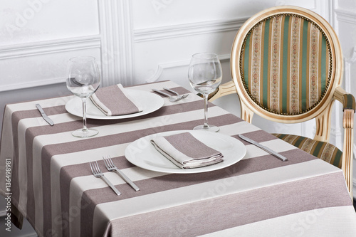 Beautiful decorated table with linen napkins, cutlery on luxurious tablecloth
