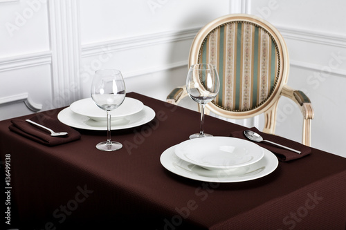 Beautiful decorated table with linen napkins, cutlery on luxurious tablecloth 