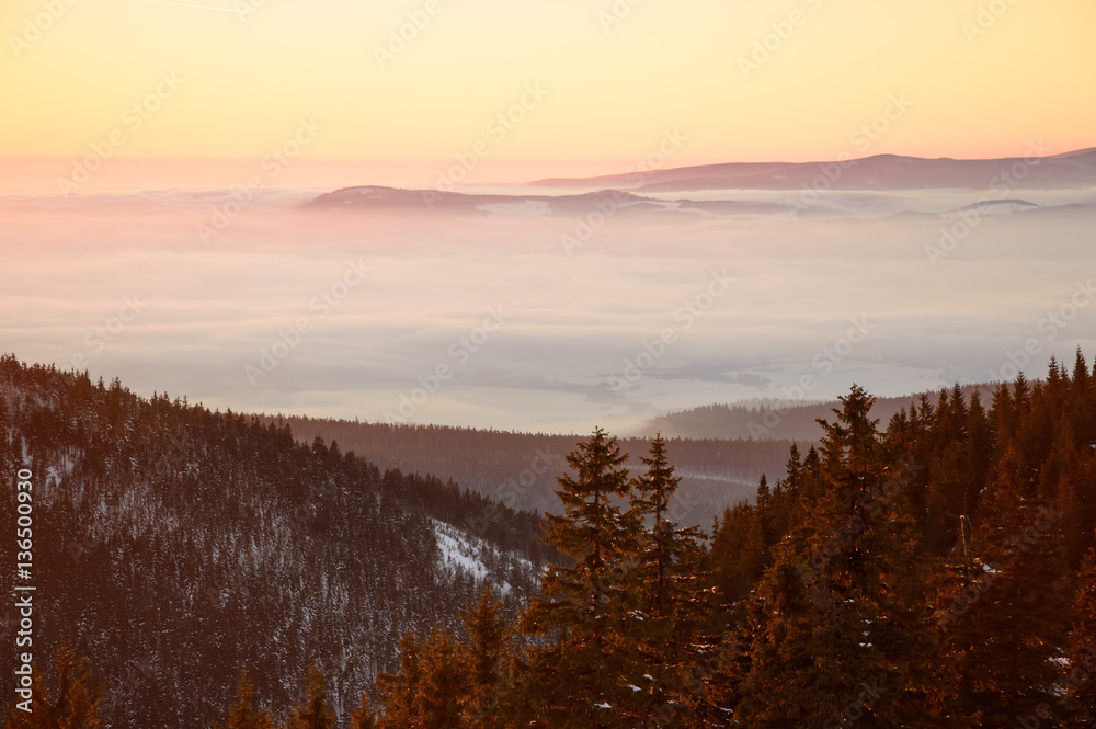 Golden sunset in the mountains, a vast fog over the valley Golden sunset in the mountains, a vast fog over the valley