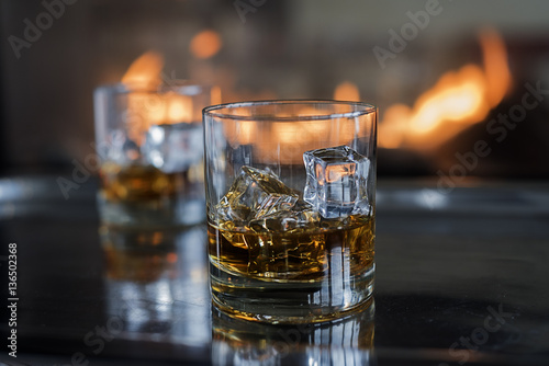 Two Scotch on the rocks cocktails by the fire