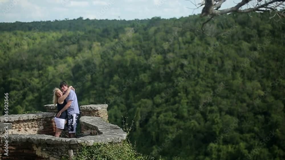 Young lovely couple embracing on medieval wall shot