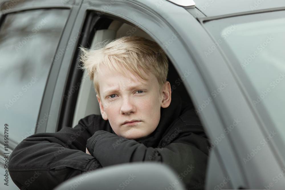 Serious boy with folded arms in car Serious boy with folded arms in car