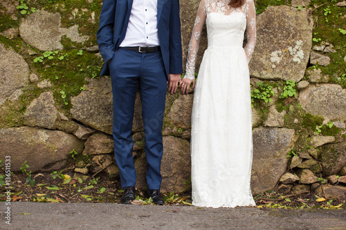 A pair of newlyweds in an old stone wall