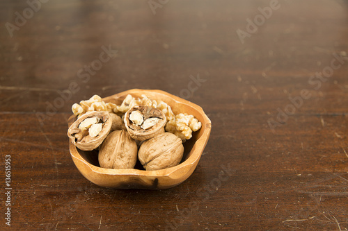 Bowl of walnuts photographed from a high advantage on an antique wooden table photo