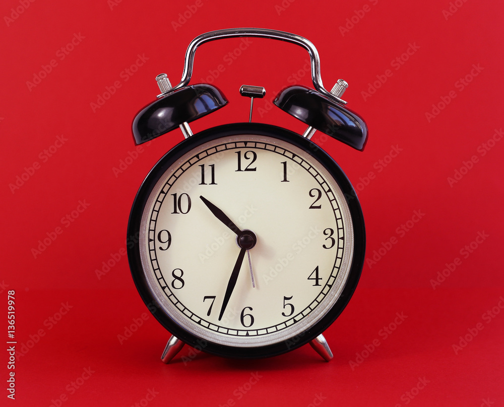 Naklejka premium classic table clock on a red background. interior Features