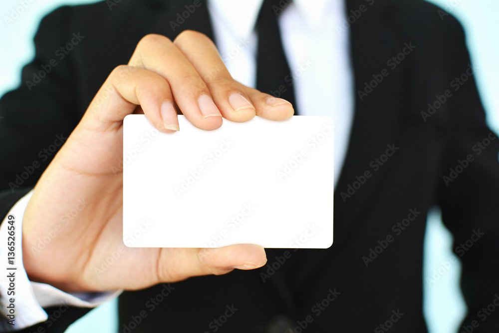 Close up of businesswomen holding card on blue background selective and soft focus Close up of businesswomen holding card on blue background selective and soft focus
