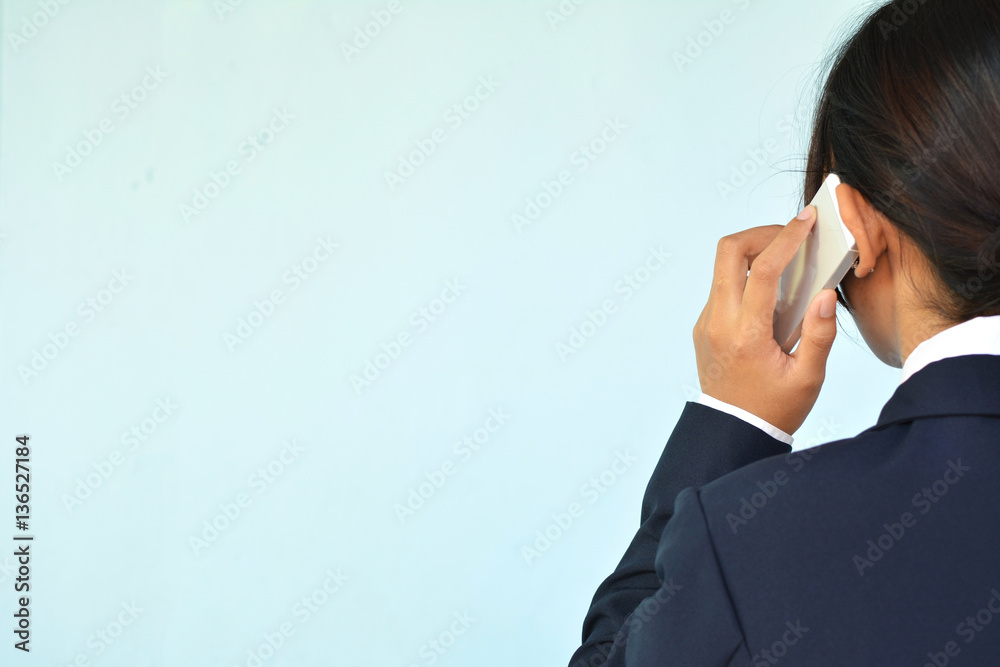 Businesswomen using smartphone on blue background selective and soft focus Businesswomen using smartphone on blue background selective and soft focus