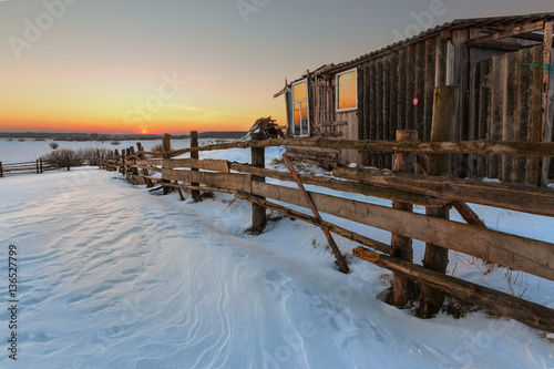 Fototapeta Naklejka Na Ścianę i Meble -  abandoned house in a field in winter village at dawn