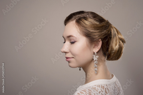 head of woman with hair in bun on gray isolated background