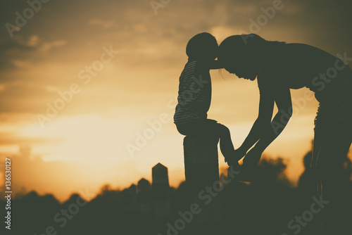 Silhouette of a family comprising mother and children at sunset