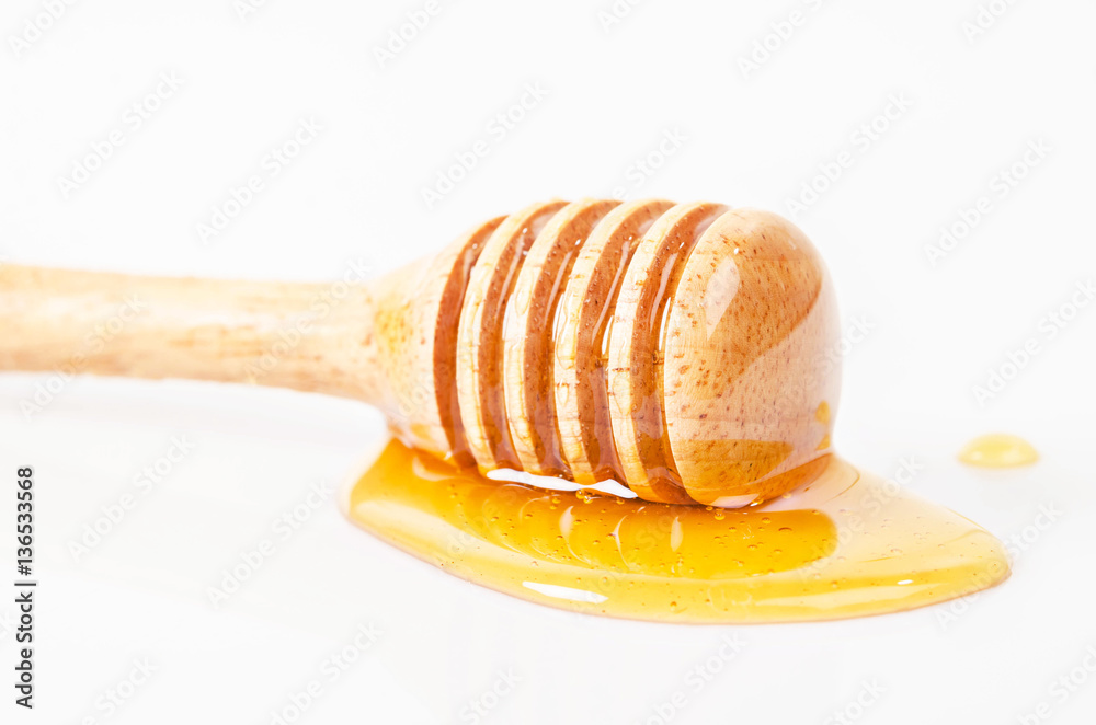 Honey dripping with honey stick.