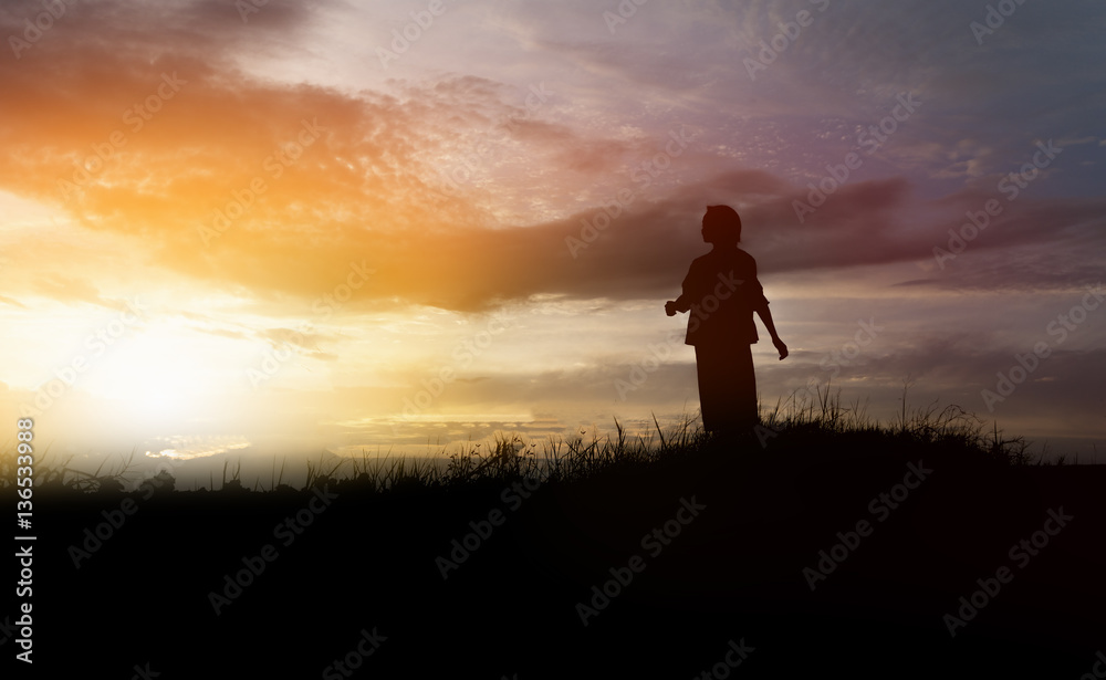 silhouette of woman walking on the mountain at sunset