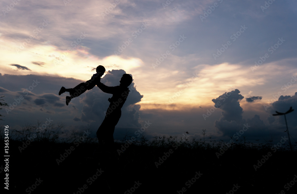 Silhouette of a family comprising father and children at sunset