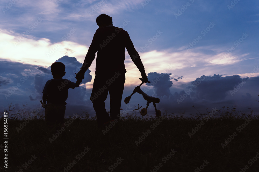 Silhouette of a family comprising father and children at sunset