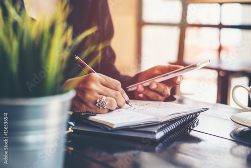 home office desk background,hand holding pencil and writing note on wood table,Checklist Notice Remember Planning Concept photo