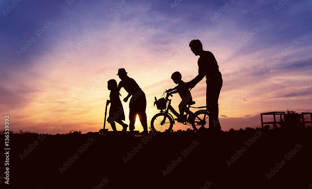 Fototapeta premium Happy asian family playing at grass on sunset