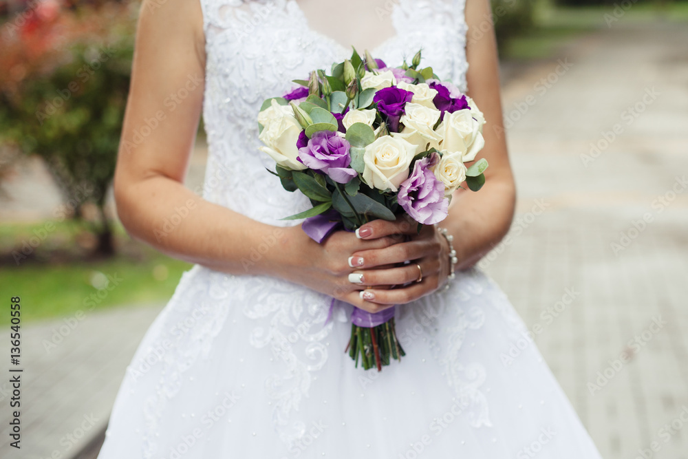 Wedding. The bride in a dress standing in a green garden and hol Wedding. The bride in a dress standing in a green garden and hol