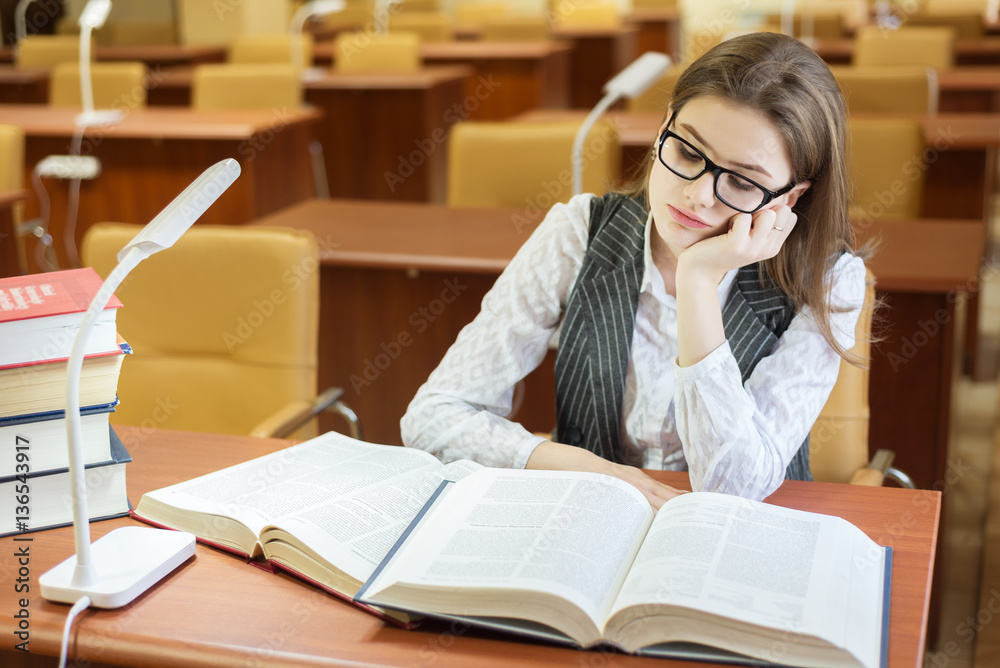 young woman reading book in library. Copy Space