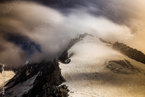 Long exposure shoot of a high mountain peak covered with fast moving clouds