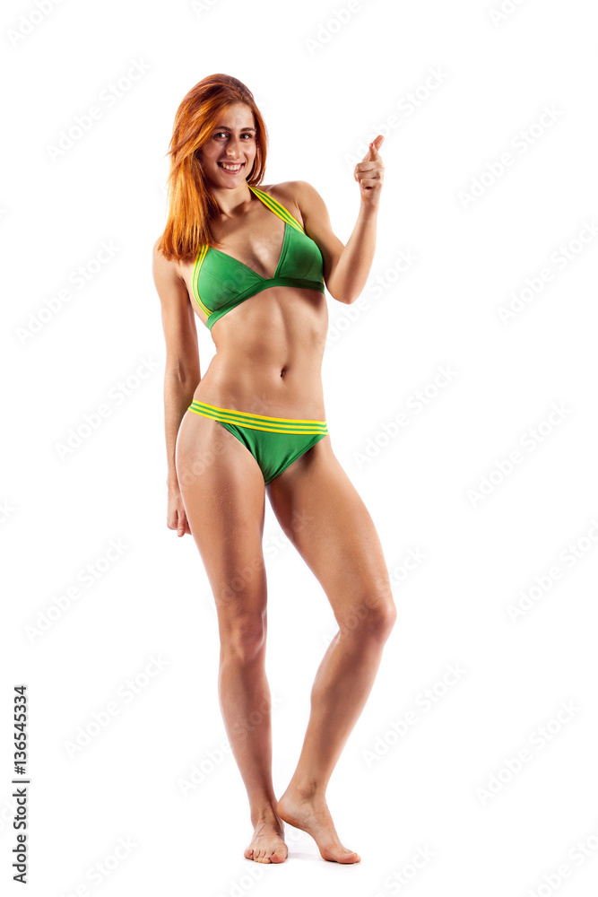 Fototapeta premium Beautiful sporty woman demonstrating press stomach and looks directly at the camera.