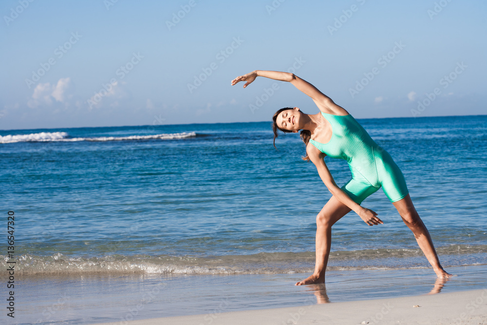 femme qui fait des exercices de gymnastique sur la plage en été femme qui fait des exercices de gymnastique sur la plage en été